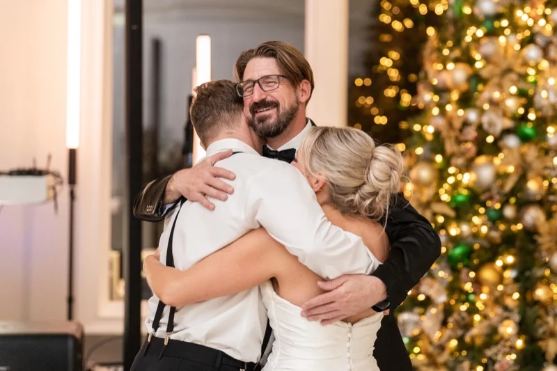 Craig and Ashley embracing DJ Corey at the end of their wedding reception