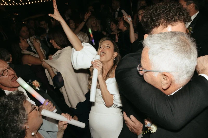 Bride celebrating with guests on dance floor