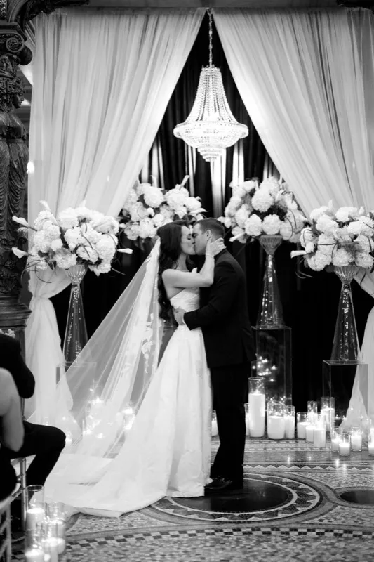 Bride and groom kissing under the chandelier at the Grand Parlor Rotunda Flagler College St. Augustine wedding ceremony