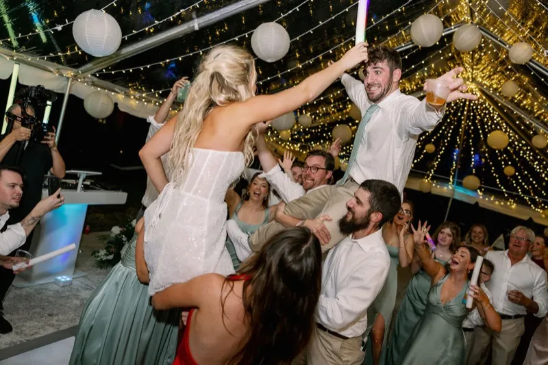 Bride and groom lifted by wedding guests at Fountain of Youth celebration