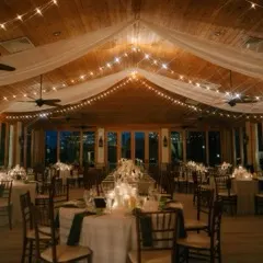 A reception under ceiling draping and warm cafe lights installed by St. Johns Illuminations
