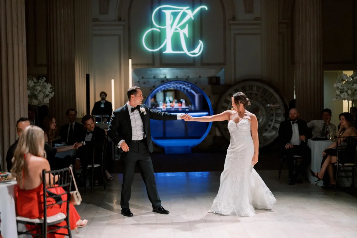 Bride and groom first dance under custom monogram projection at Treasury on the Plaza, St. Augustine