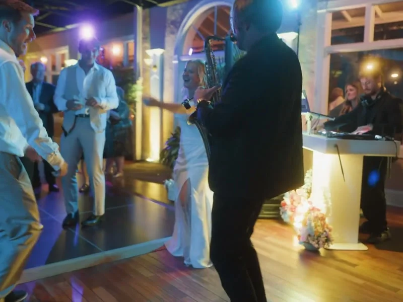 DJ Corey playing live saxophone while bride dances at White Room wedding reception